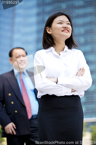 Image of Asian businessman & young female executive smiling portrait