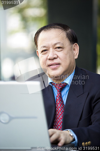 Image of Asian businessman using laptop
