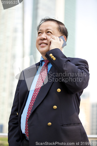 Image of Asian businessman talking on smart phone