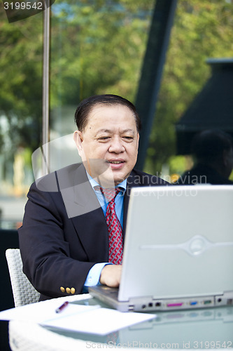 Image of Asian businessman using laptop