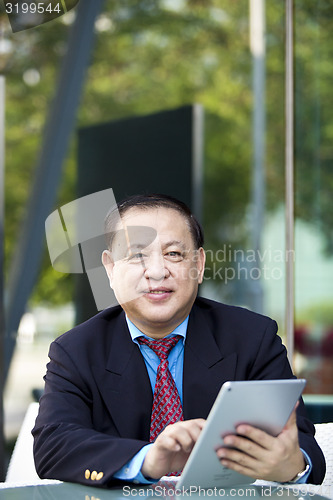 Image of Asian businessman using tablet