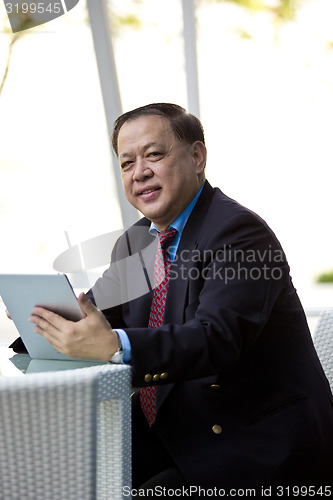 Image of Asian businessman using tablet