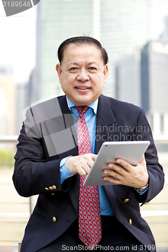 Image of Asian businessman using tablet