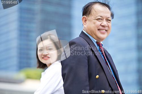 Image of Asian businessman & young female executive smiling portrait