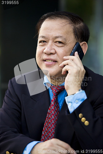 Image of Asian businessman talking on smart phone