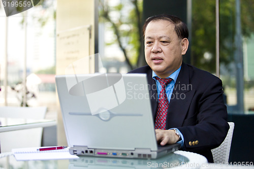 Image of Asian businessman using laptop