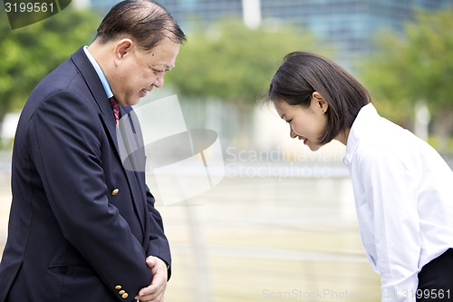 Image of Asian businessman and young female executive bowing