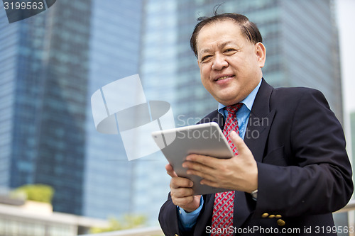 Image of Asian businessman using tablet