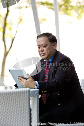 Image of Asian businessman using tablet