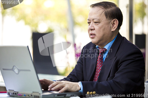 Image of Asian businessman using laptop