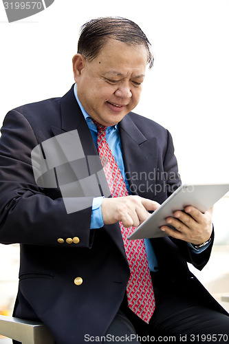 Image of Asian businessman using tablet