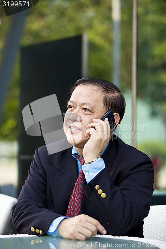 Image of Asian businessman talking on smart phone