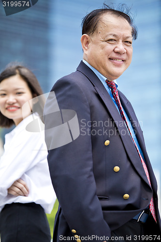 Image of Asian businessman and young female executive smiling portrait