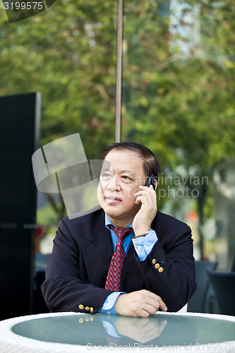 Image of Asian businessman talking on smart phone