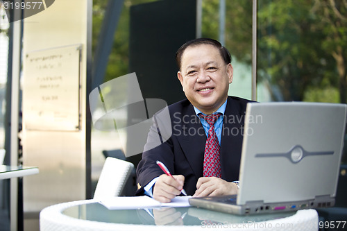 Image of Asian businessman writing proposal