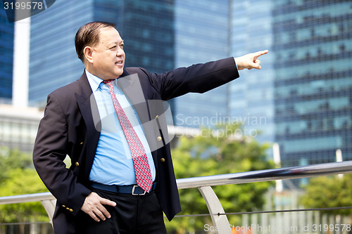 Image of Asian businessman pointing at a direction