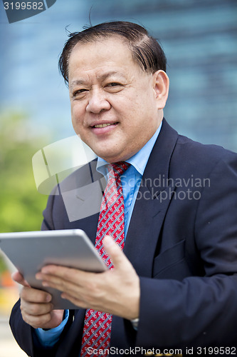 Image of Asian businessman using tablet