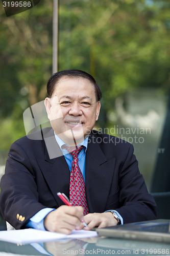 Image of Asian businessman writing proposal