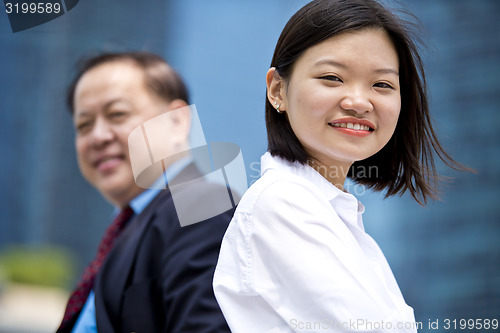 Image of Asian businessman and young female executive smiling portrait