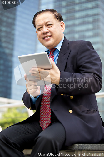 Image of Asian businessman using tablet