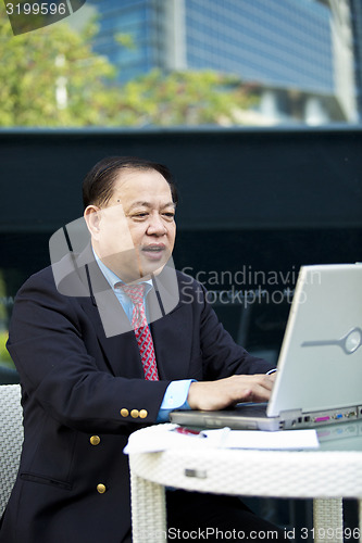 Image of Asian businessman using laptop