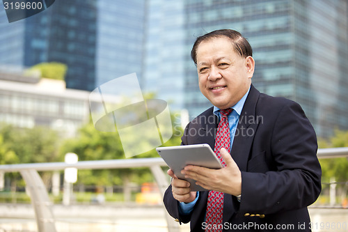 Image of Asian businessman using tablet