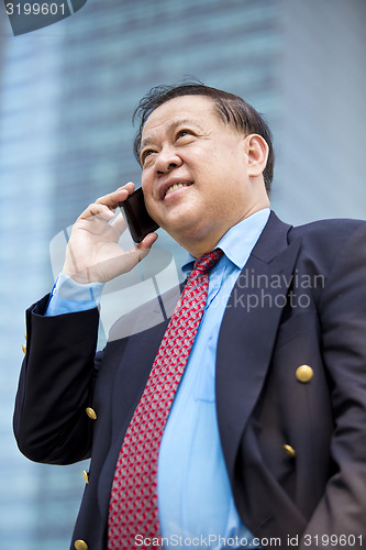 Image of Asian businessman talking on smart phone