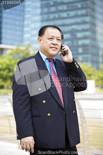 Image of Asian businessman talking on smart phone