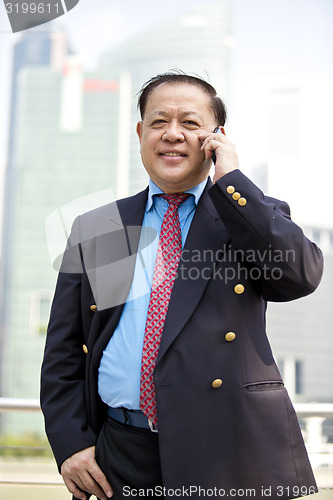 Image of Asian businessman talking on smart phone