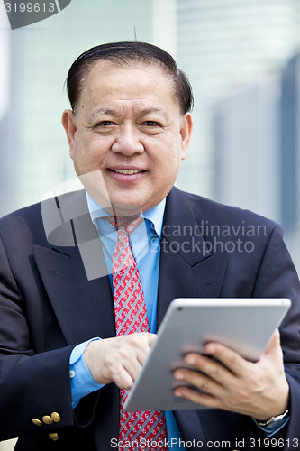 Image of Asian businessman using tablet