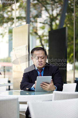 Image of Asian businessman using tablet