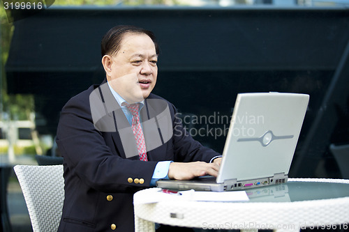 Image of Asian businessman using laptop