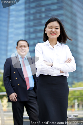 Image of Asian businessman and young female executive smiling portrait