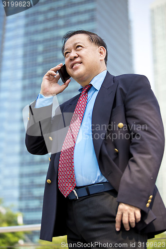 Image of Asian businessman talking on smart phone