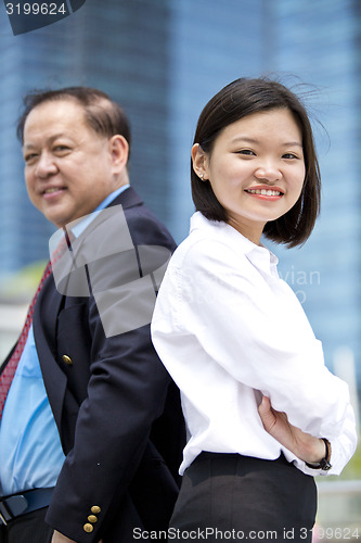 Image of Asian businessman and young female executive smiling portrait