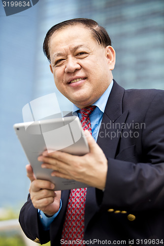 Image of Asian businessman using tablet