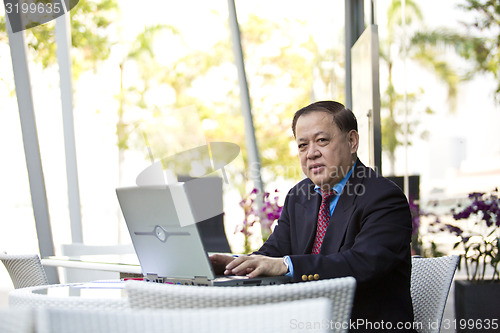 Image of Asian businessman using laptop