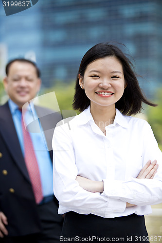 Image of Asian businessman and young female executive smiling portrait