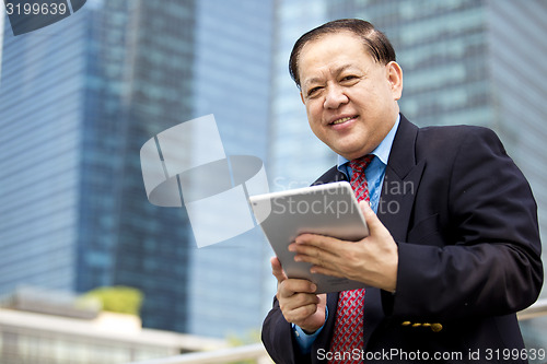 Image of Asian businessman using tablet