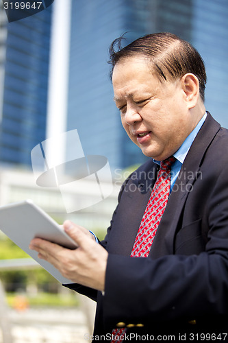 Image of Asian businessman using tablet