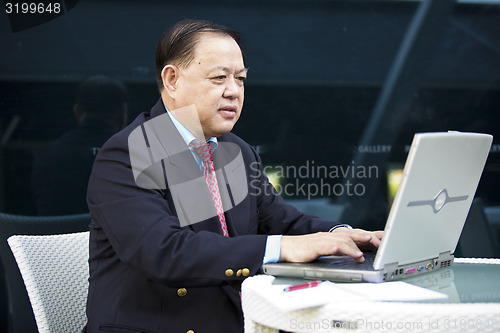 Image of Asian businessman using laptop