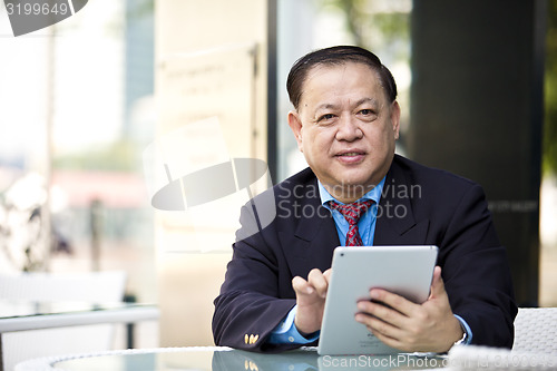 Image of Asian businessman using tablet