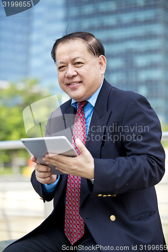 Image of Asian businessman using tablet