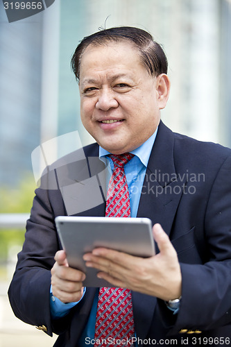Image of Asian businessman using tablet