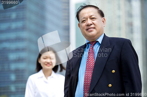 Image of Asian businessman and young female executive smiling portrait