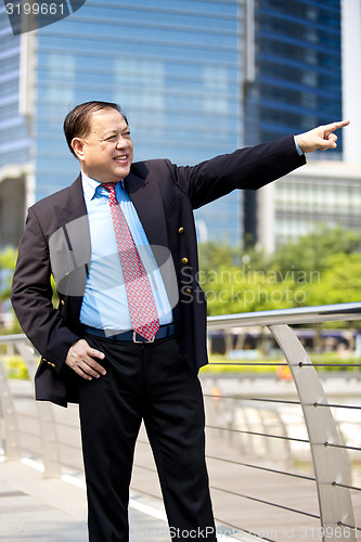 Image of Asian businessman smiling pointing at a direction