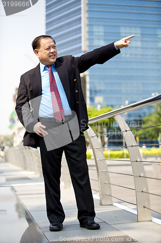 Image of Asian businessman smiling pointing at a direction