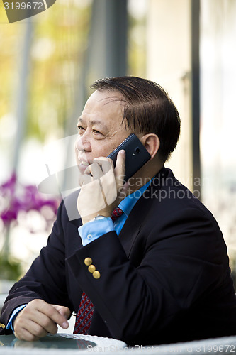 Image of Asian businessman talking on smart phone