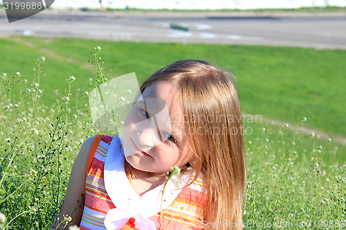 Image of portrait of little girl lying on the grass