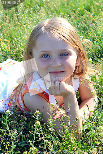 Image of portrait of little girl lying on the grass